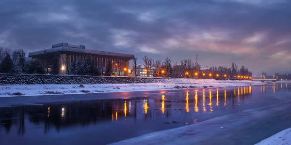 ウズホード ウクライナ 12月2016 夜明けに冬の街並み 川の美しい景色がある 水の中に映る街の灯り 堤防の雪 — ストック写真
