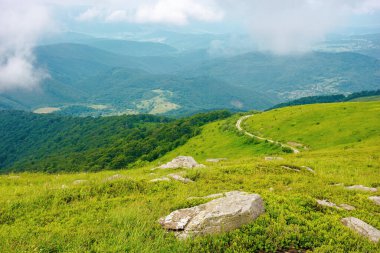 Dağ tepelerinden geçen yol. Sabahları güzel bir yaz manzarası. Gökyüzündeki bulutlar