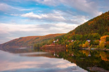Dağ Gölü 'nde bir konsolos gün batımında aradı. Cluj ülkesi Romanya 'nın güzel sonbahar kırsal manzarası. Tepedeki ağaçlar renkli yapraklar ve gökyüzündeki bulutlar su yüzeyine yansıyor.