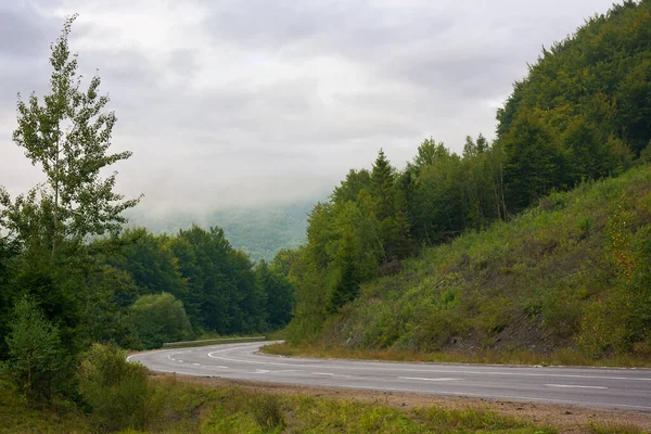 Bulutlu bir günde dağların arasından asfalt yol. harika kırsal alan sonbaharın başlarında