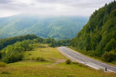 Bulutlu bir günde dağların arasından asfalt yol. harika kırsal alan sonbaharın başlarında
