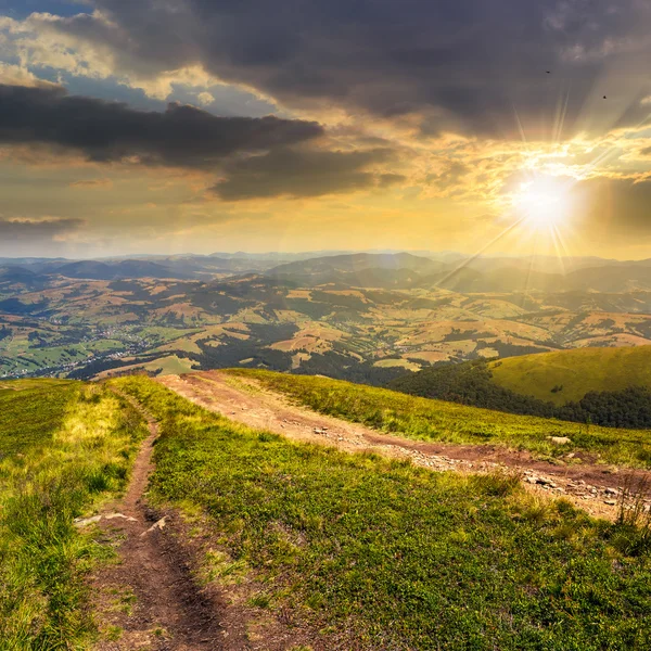 Path to village in mountain valley at sunset — Stock Photo, Image