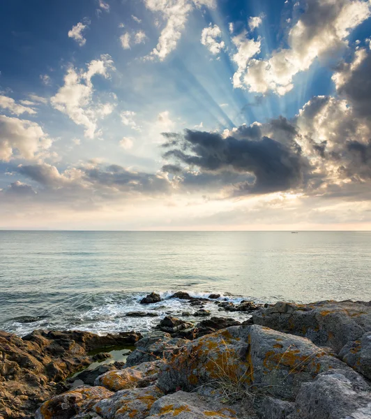 Sea wave breaks about rocky shore at sunrise — Stock Photo, Image