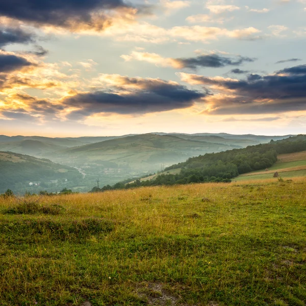 Campo perto de declive em casa ao nascer do sol — Fotografia de Stock