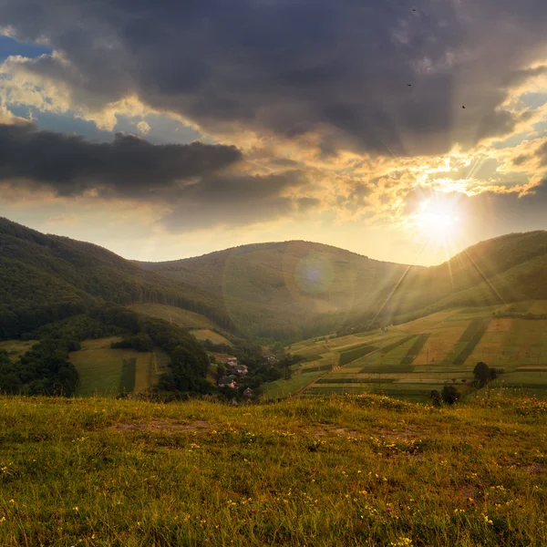 Campo perto de casa nas montanhas ao pôr do sol — Fotografia de Stock