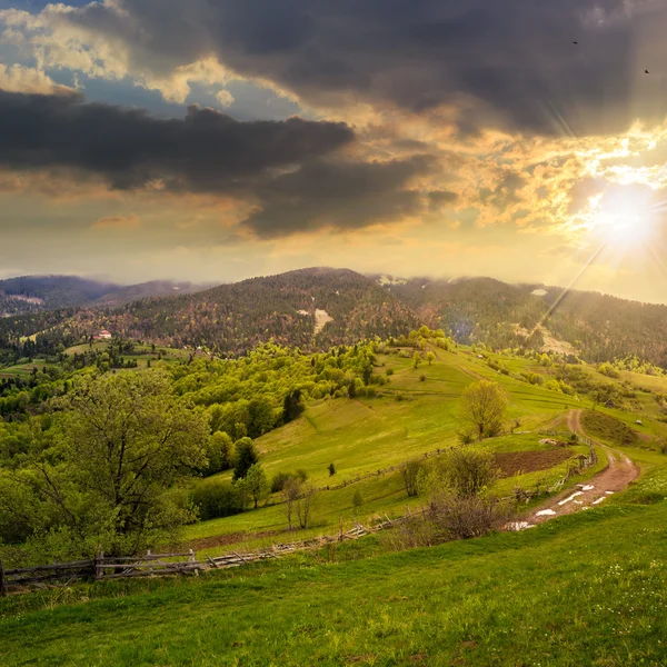Płot na wzgórzu łąka w górach na zachodzie słońca — Zdjęcie stockowe