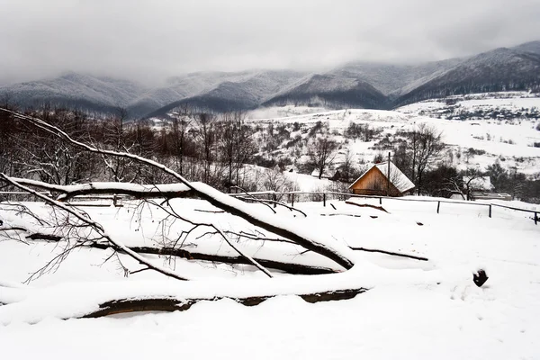 Snowy road to village in mountains — Stock Photo, Image