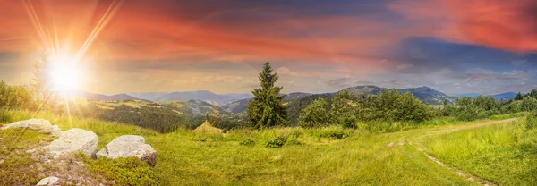 Boulders su prati collinari in montagna al tramonto — Foto Stock