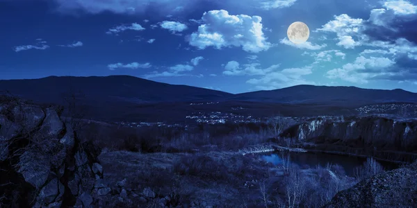 Dağlar ocağı gece şehir yakınındaki gölde — Stok fotoğraf