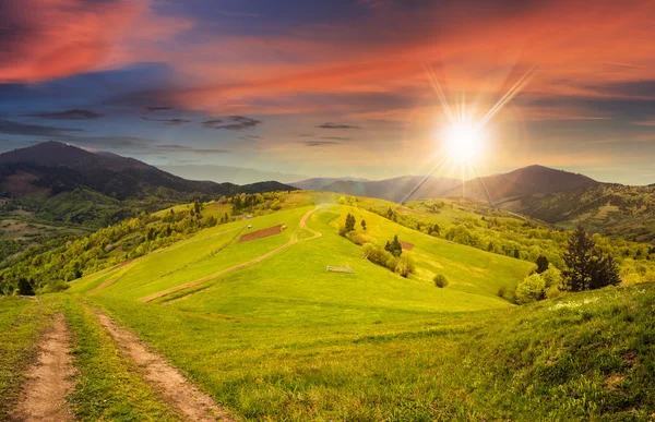 Recinzione sul prato collinare in montagna al tramonto — Foto Stock