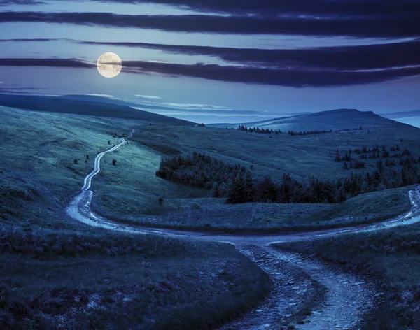 Kruispunt op heuvel weide in berg bij zonsopgang bij nacht — Stockfoto