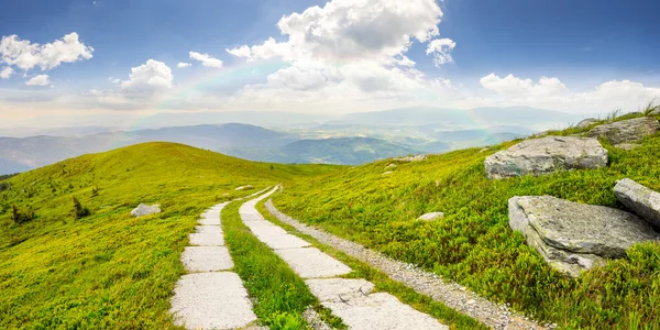 Estrada em uma encosta perto do pico da montanha ao nascer do sol — Fotografia de Stock