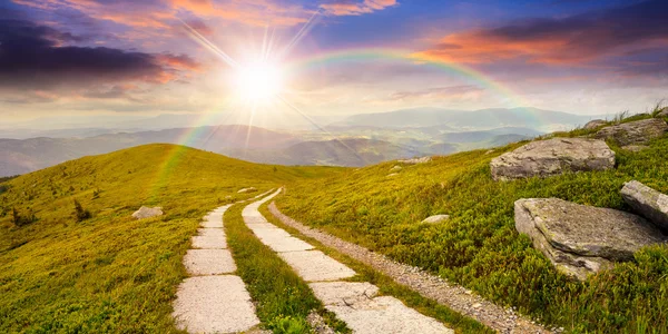 Estrada em uma encosta perto do pico da montanha no por do sol — Fotografia de Stock