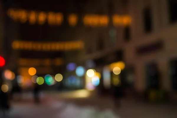 Människor som flyttar på gamla staden vinternatten gatan suddig — Stockfoto