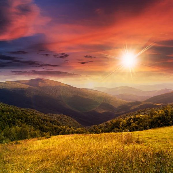 Prado em altas montanhas ao pôr do sol — Fotografia de Stock