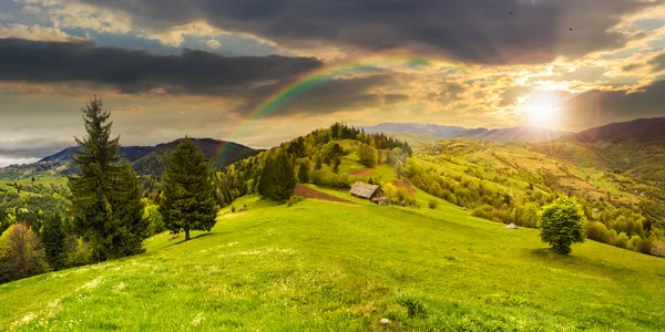 Celeiro abandonado nas montanhas ao pôr do sol — Fotografia de Stock