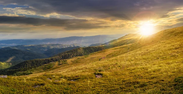 Údolí na svahu pohoří při západu slunce — Stock fotografie