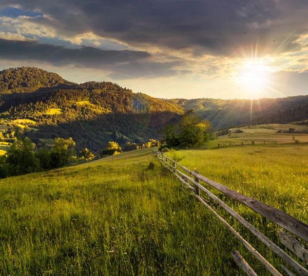 Gard pe pajiște pe deal în munte la apus de soare — Fotografie, imagine de stoc