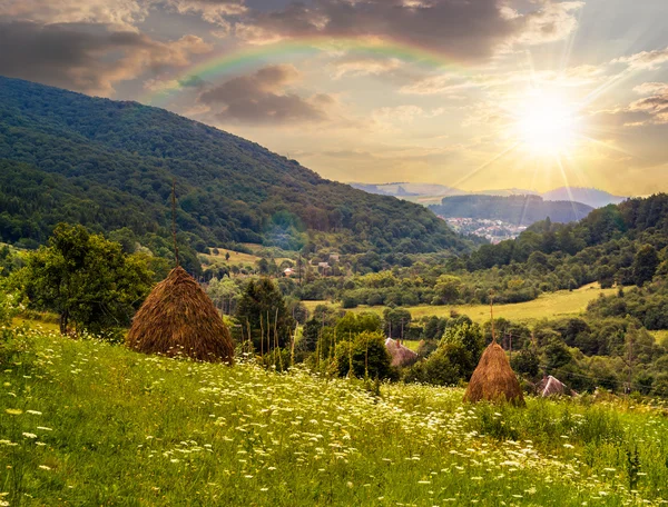 Feld mit Heuhaufen am Hang bei Sonnenuntergang — Stockfoto