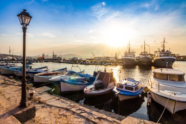 fishing boats in port of Sozopol at sunset clipart