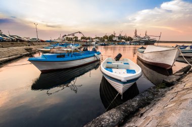 fishing boats in port of Sozopol at sunrise clipart