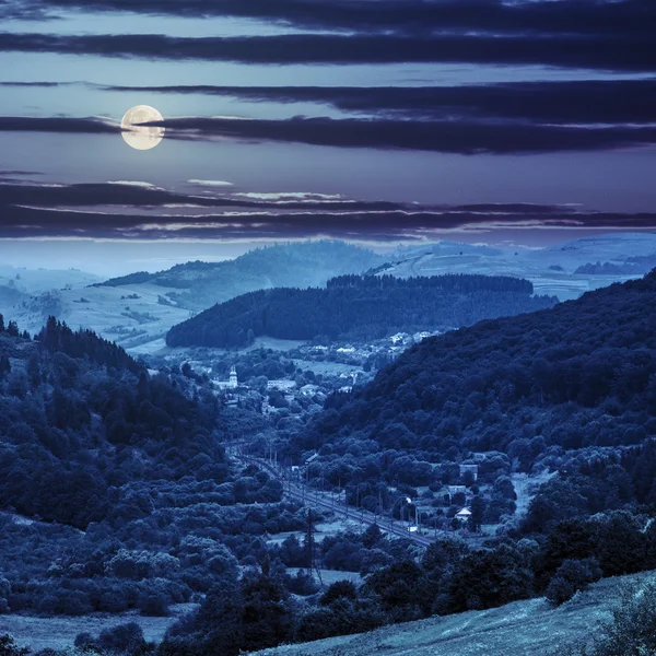 Caminho de ferro para aldeia nas montanhas à noite — Fotografia de Stock