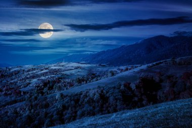 Sonbaharda geceleri dağ manzarası. Rengarenk yaprakları olan güzel bir manzara. Alplerde, dolunay ışığında kırsal bir yer. Kırsal manzara