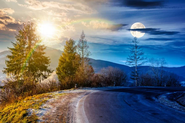 Dağlardaki köy yolu. Gündüz ve gece zaman kavramını değiştirir. Sonbaharın sonlarında güzel bir kır manzarası. Yol kenarındaki köknar ağaçlarında güneş ve ay var. Kardaki uzak tepenin manzarası