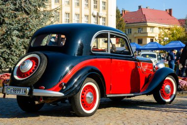 Uzhhorod, Ukrayna - 31 Ekim 2021: siyah bluzlu kırmızı bmw 321 'in arka görüntüsü. 40 'lı yılların klasiği. Bagajında maskot olan yedek tekerlek. Sonbaharda Narodna Meydanı 'nda klasik araç sergisi