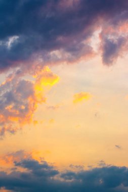 dark cloudscape at sunset. orange-purple clouds on a yellow-blue gradient of sky in evening light. dramatic weather change. wind forecast background. place for copy space. narrow telephoto shot