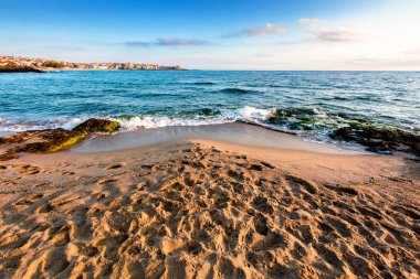 Tatlı mevsimde kumlu bir kumsalda gün doğumu. Karadeniz kıyılarında güzel ve sıcak bir hava var. Sozopol Sahili Sabah Işığı