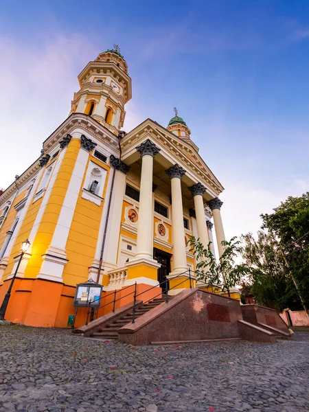 Uzhorod, Ukrayna - 04 Haziran 2017: Yazın gündoğumunda kutsal haç katedrali. Eski şehrin merkezindeki Yunan Katolik kilisesinin güzel manzarası. Mavi gökyüzünün altında güneşli bir sabahta kubbe ve sütunlar