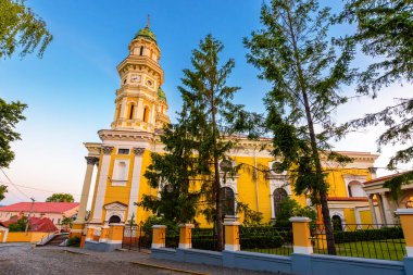 Uzhorod, Ukrayna - 04 Haziran 2017: Yazın gündoğumunda kutsal haç katedrali. Eski şehrin merkezindeki Yunan Katolik kilisesinin güzel manzarası. Mavi gökyüzünün altında güneşli bir sabahta kubbe ve sütunlar