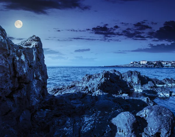 Zee baai met keien en oude stad bij nacht — Stockfoto