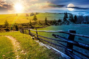 İlkbahar ekinoksunda dağlardaki güzel kırsal alan. Gündüz ve gece zaman kavramını değiştirir. Çitlerin yanındaki yol samanlıkta ve kozalaklı ağaçlarla alacakaranlıkta güneş ve ay ile