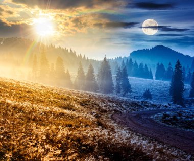 Sonbahar ekinoksunda dağ manzarası boyunca kırsal yol. Gündüz ve gece zaman kavramını değiştirir. Sis içinde yuvarlanan tepelerde kozalaklı orman. Güneş ve ay olan doğal park. güzel kırsal arkaplan