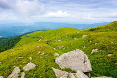 Yazın dağlık çayırlarda muazzam kayalıklarla nefes kesici dağ manzarası. Karpat Alplerinin güzel doğası. Tepeleri ve bulutlu gökyüzünün altında yeşil yamaçları olan dramatik bir manzara. Açık hava macerası