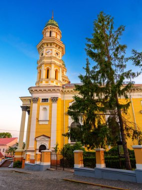 Uzhorod, Ukrayna - 04 Haziran 2017: Yazın gündoğumunda kutsal haç katedrali. Eski şehrin merkezindeki Yunan Katolik kilisesinin güzel manzarası. Mavi gökyüzünün altında güneşli bir sabahta kubbe ve sütunlar