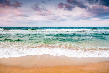 Karadeniz dalgaları, Bulgaria 'nın kumlu sahillerine çarpıyor. Kara bulutlu bir gökyüzünün altında rüzgarlı bir havada yaz tatili. Dramatik deniz manzarası. Kötü hava konseptinde umutsuz turizm için arka plan
