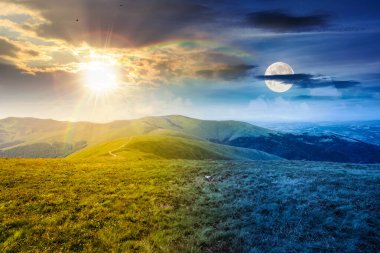Yaz gündönümünde dağlardaki dağlık çayırlarda. Gündüz ve gece zaman kavramını değiştirir. Gökyüzünün altında yemyeşil çimenler ve güneş ve ay olan yuvarlanan tepelerin güzel manzarası. ikilik ve geçiş şablonu