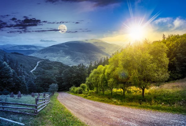 Clôture près de la route en bas de la colline avec forêt dans les montagnes jour et — Photo