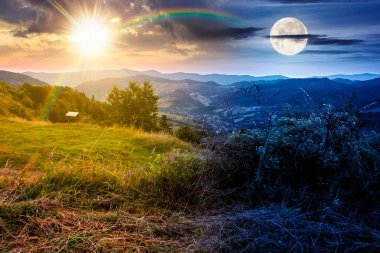 Yaz gündönümünde dağların sabah manzarası. Gündüz ve gece zaman kavramını değiştirir. Kırsal vadide güneş ve ay var. Kırsal kesimin güzelliği. organik saman tarlası yeşili çevre. çarpıcı bir yer.