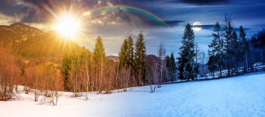 İlkbahar ekinoksunda ormanla kaplı kar. Gündüz ve gece zaman kavramını değiştirir. Güneşli ve aylı dağlık kırsal manzaranın çarpıcı manzarası. ikilik ve geçiş şablonu
