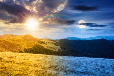 Çimenli tepe çayırları olan bir manzara. Gündüz ve gece zaman kavramını değiştirir. Yaz gündönümünde dağ manzarası. Alacakaranlıkta güneş ve ay. seyahat geçmişi. Doğa ikiliği ve geçiş şablonu
