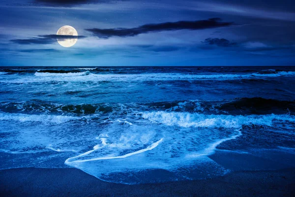 Karadeniz dalgaları gece kumsala vuruyor. Dolunay ışığında karanlık bulutlu gökyüzünün altında rüzgarlı bir havada yaz tatili. Dramatik deniz manzarası. Yatırım veya soyut kavramlar için arkaplan