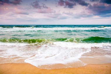 Karadeniz dalgaları, Bulgaria 'nın kumlu sahillerine çarpıyor. Kara bulutlu bir gökyüzünün altında rüzgarlı bir havada yaz tatili. Dramatik deniz manzarası. Kötü hava konseptinde umutsuz turizm için arka plan