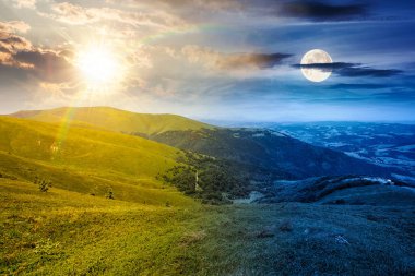 Yaz gündönümünde dağlardaki dağlık çayırlarda. Gündüz ve gece zaman kavramını değiştirir. Gökyüzünün altında yemyeşil çimenler ve güneş ve ay olan yuvarlanan tepelerin güzel manzarası. ikilik ve geçiş şablonu