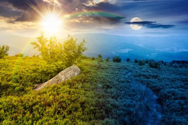 Dağ manzarası boyunca yürüyüş parkurları. Gündüz ve gece zaman kavramını değiştirir. Alacakaranlıkta güneş ve ay ile gökyüzünün altında dağlar. Yeşil çimenli ve yuvarlanan tepeli manzara. eşitlik ve kayma şablonu