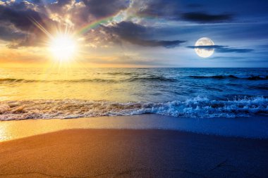Yaz gündönümü tatili için deniz kıyısındaki kumsal. Gündüz ve gece zaman kavramını değiştirir. Sakin dalgalar, güneş ve ay ile mükemmel sahilde güzel bir gün doğumu. ikilik ve geçiş şablonu için manzara