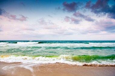 Karadeniz dalgaları, Bulgaria 'nın kumlu sahillerine çarpıyor. Kara bulutlu bir gökyüzünün altında rüzgarlı bir havada yaz tatili. Dramatik deniz manzarası. Kötü hava konseptinde umutsuz turizm için arka plan